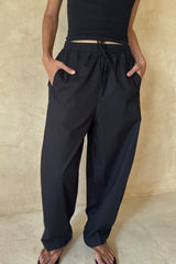 Woman wearing the black Coconut Pants styled with a basic tank top for an effortless everyday outfit.