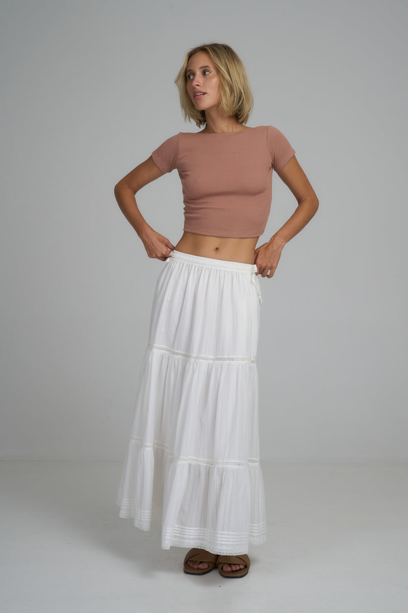 A model wearing a white lace maxi skirt