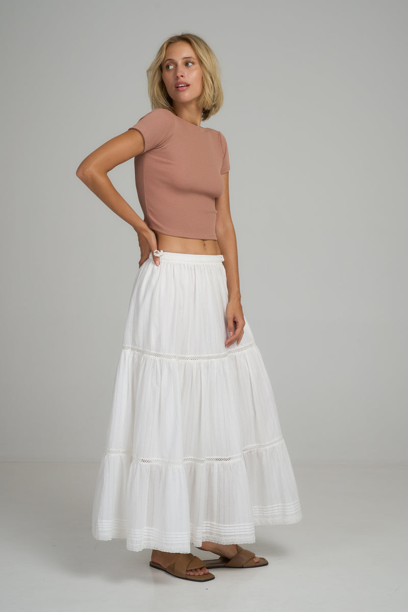 A model wearing a white cotton lace maxi skirt