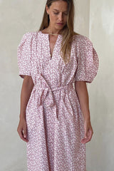 Model wears pink floral summer dress with belt