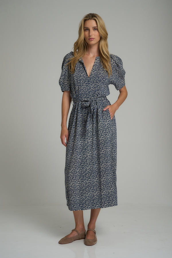 A woman wearing a blue and white floral maxi dress