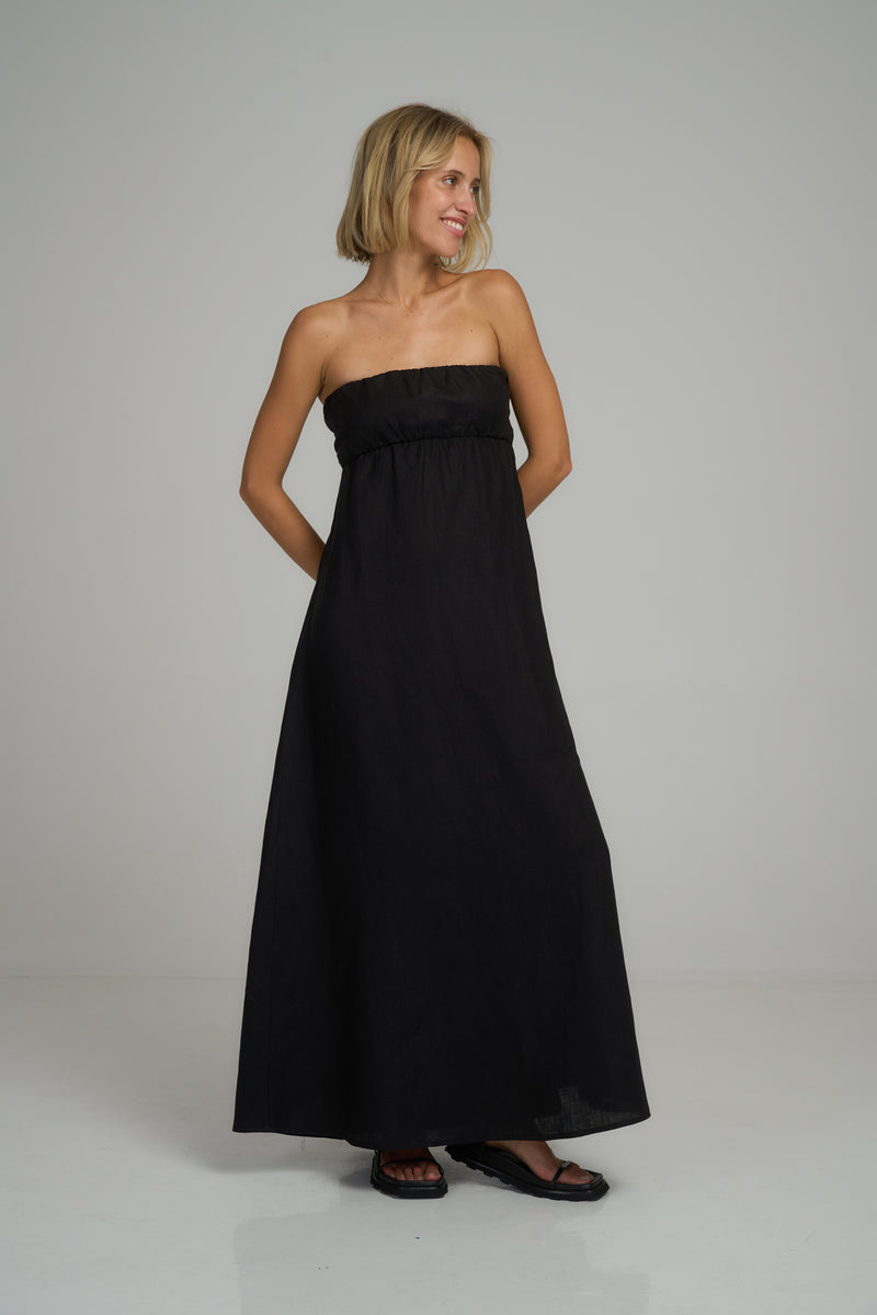 A model wearing a black strapless linen maxi dress