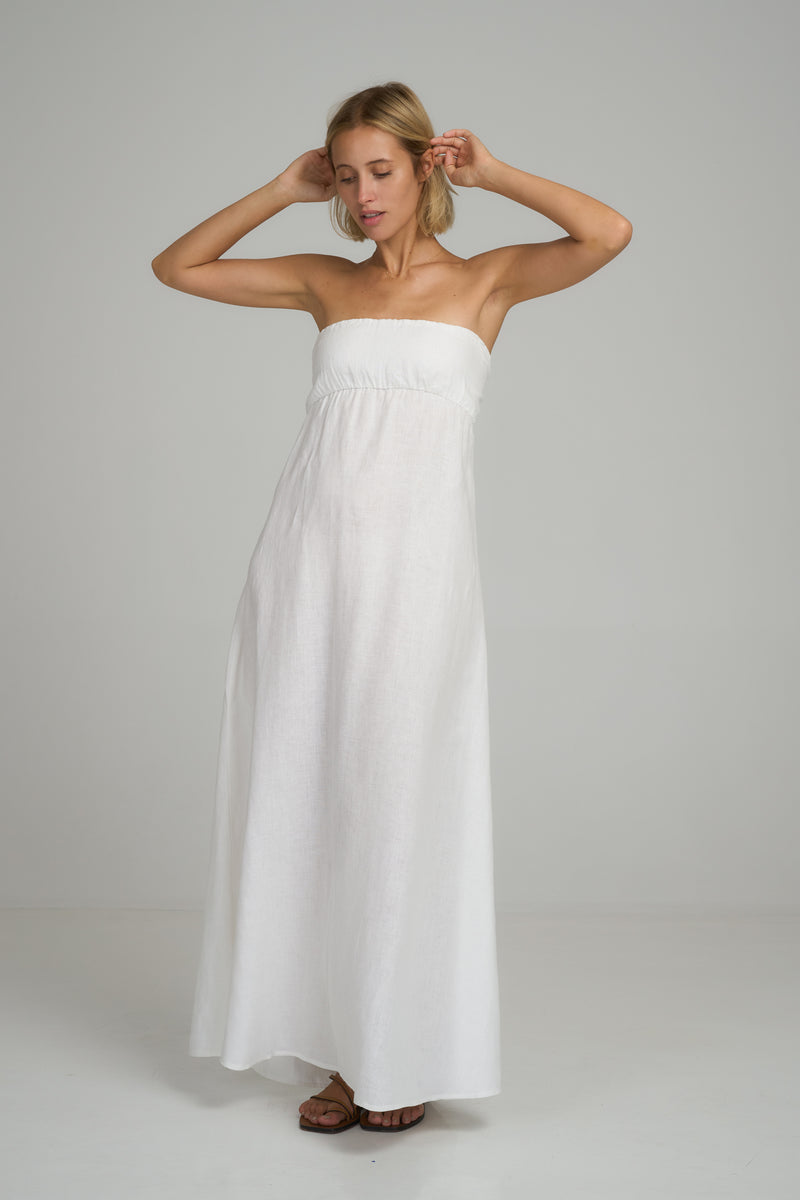 A model wearing a white strapless linen maxi dress