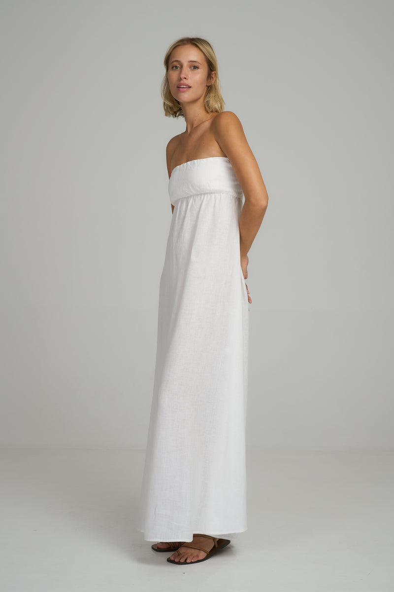 A model wearing a white summer linen strapless maxi dress