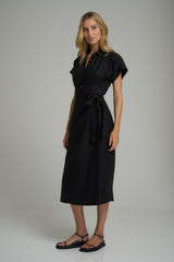 A model wearing a classic black linen wrap dress