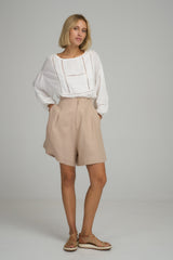 A model wearing light pink linen summer shorts