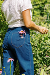 Back view of the Echinacea Jean in Dark Denim on Jess showing the embroidered Echinacea bloom.