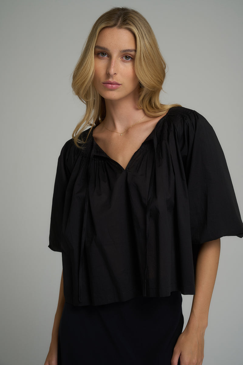 A woman wearing a black cotton casual top