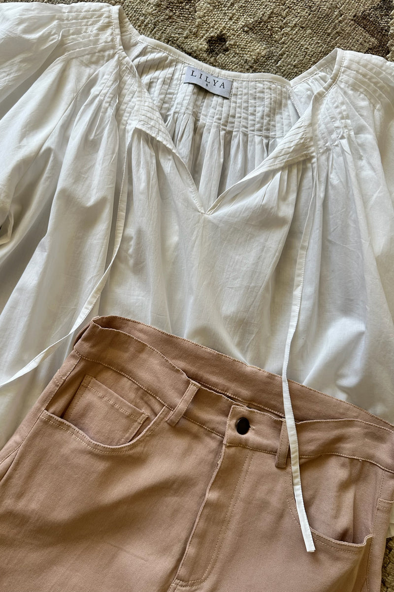 A flatlay image of a classic white linen top