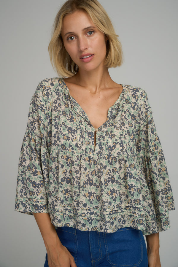 A model wearing a boho blue floral top