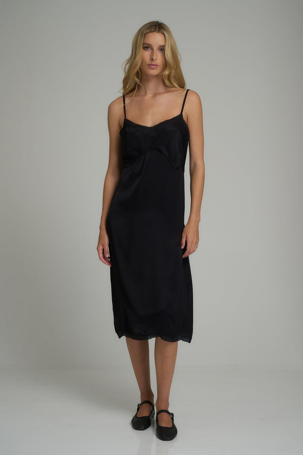 A woman wearing a black layering slip dress