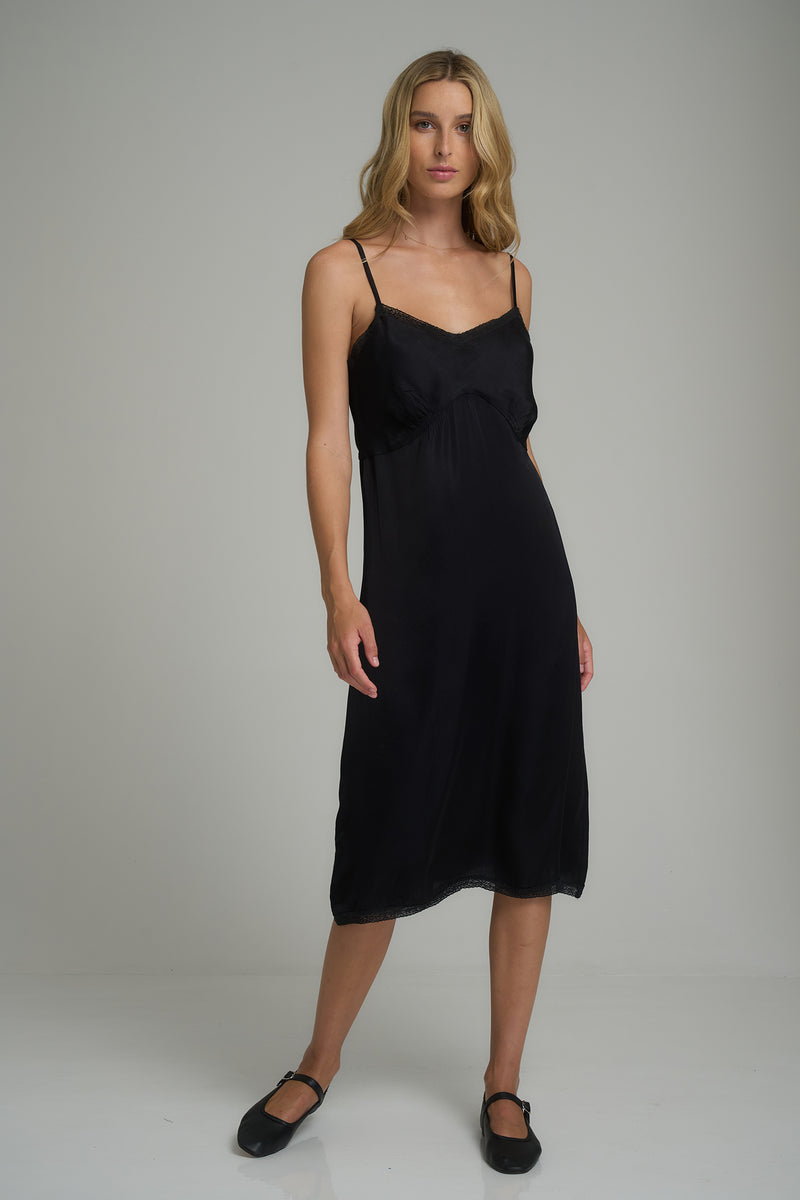 A woman wearing the Featherstone Lace Slip Dress in Black by LILYA