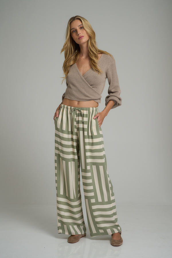 A model wearing casual green/cream pants by LILYA