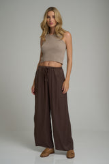 A model wearing the Fenton Pants in Chocolate by LILYA