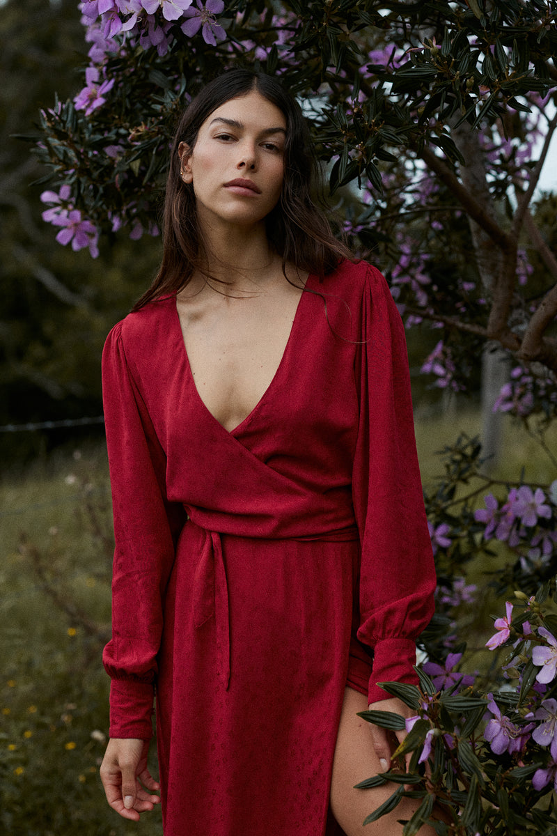 A model wearing a feminine red midi wrap dress