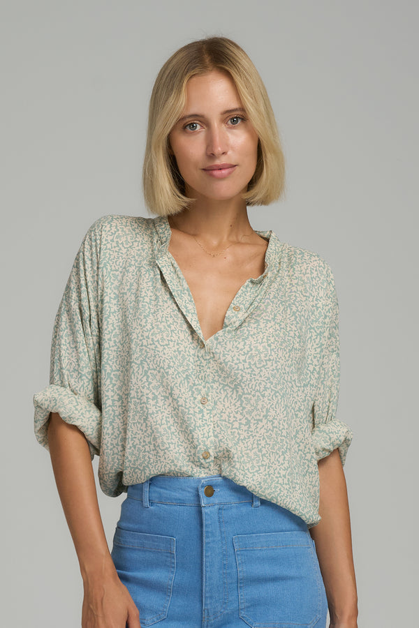 A model wearing a blue floral casual blouse