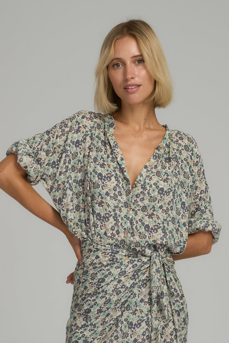 A woman wearing a casual blue floral blouse