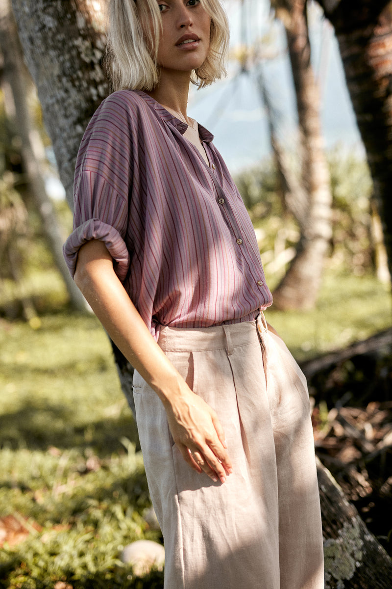 A model wearing a purple striped summer shirt