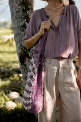 A model wearing a lilac striped long sleeve blouse