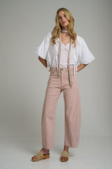 A woman wearing light pink wide leg cotton pants