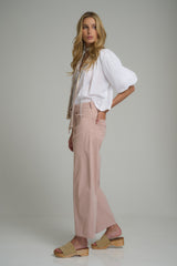 A model wearing the Guildford Cotton Pants in Pink Nougat by LILYA