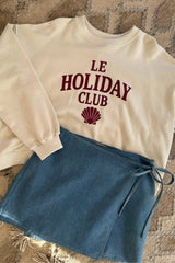 Flat lay of the Hanah Wrap denim look skirt styled with the Le Holiday Club Sweater for transeasonal dressing