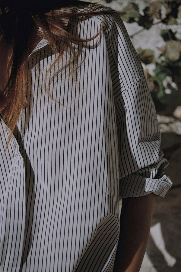 A model wearing a black and white striped cotton blouse