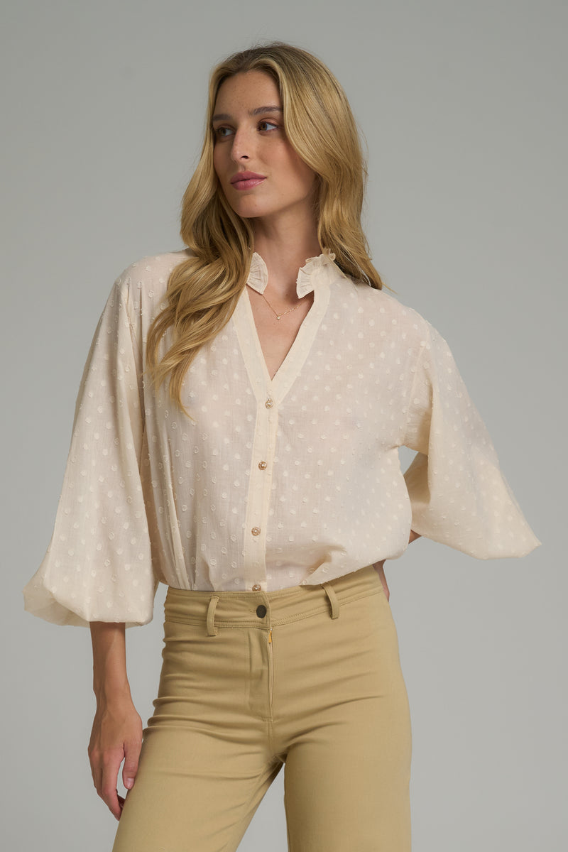 A model wearing a cream balloon sleeve cotton blouse