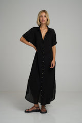 A woman wearing a black cotton maxi shirt dress for summer