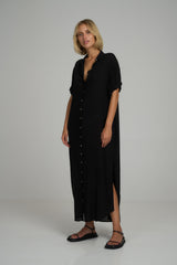 A model wearing a classic black maxi shirt dress