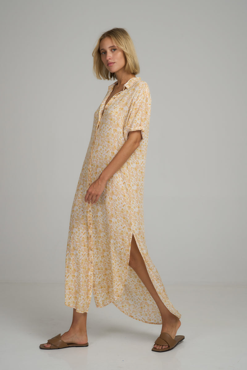 A model wearing a yellow floral maxi shirt dress