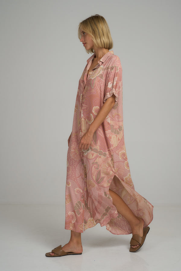 A woman wearing a pink floral maxi shirt dress