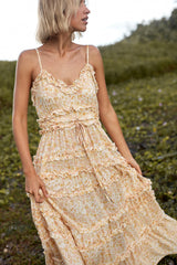 A woman wearing a summer yellow floral cotton maxi dress