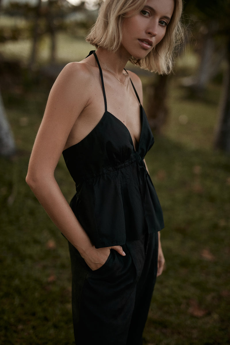 A model wearing a black cotton halter top by LILYA