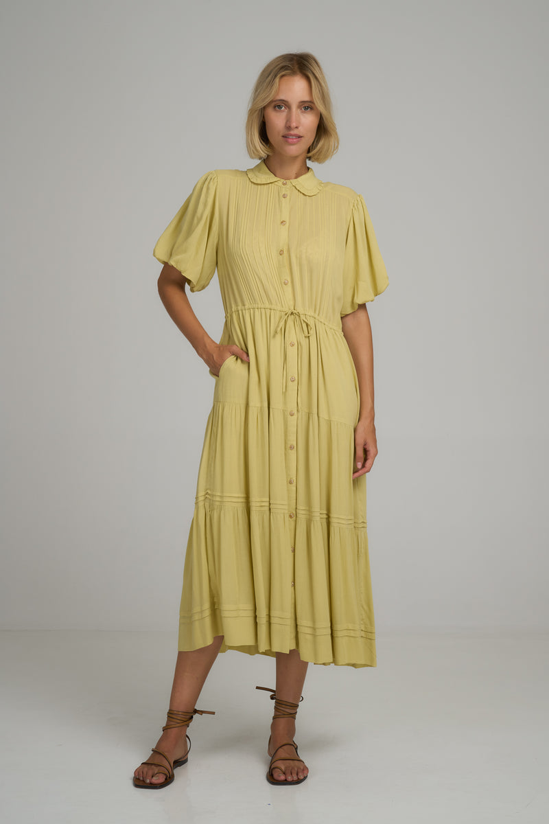 A model wearing a classic yellow pleated midi dress