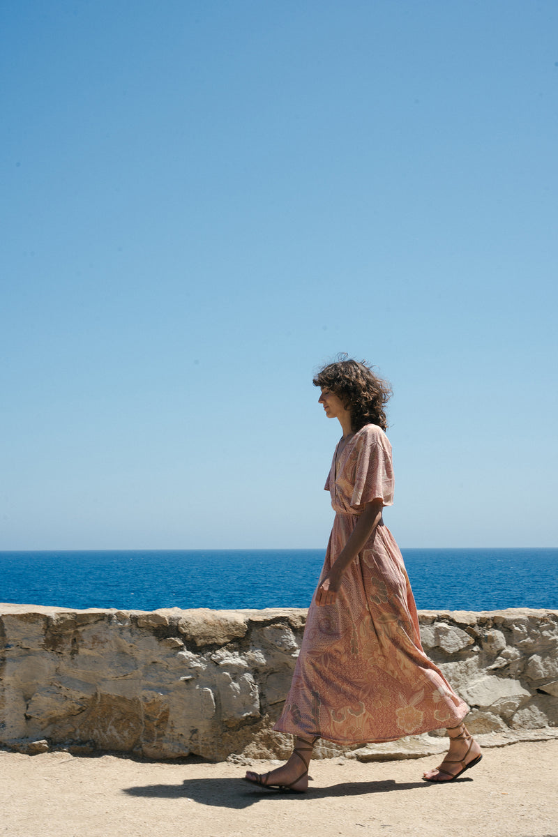 A model wearing a sexy backless summer maxi dress