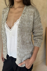 Model wearing a knitted cardigan over a white top 