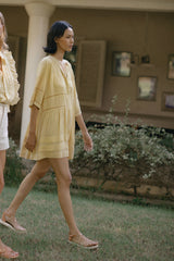 A model wearing a yellow boho mini dress