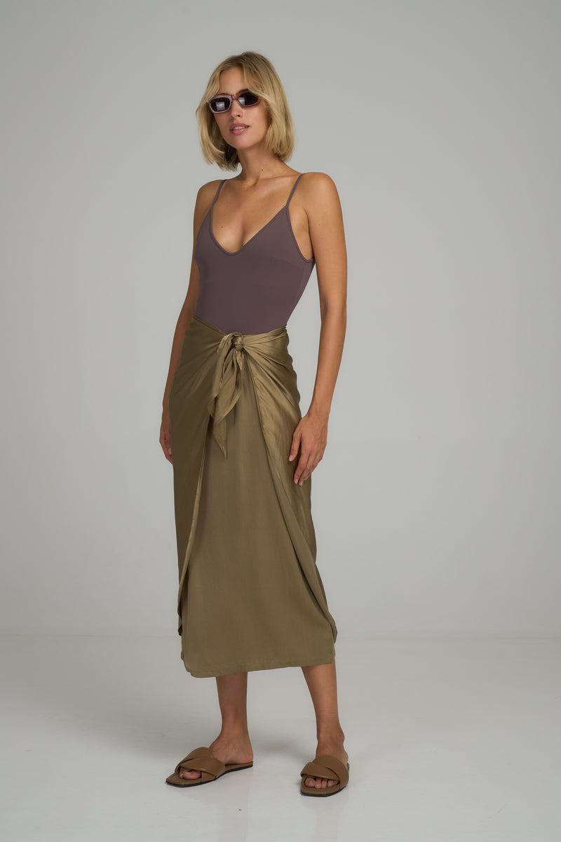 A model wearing a green silk midi wrap skirt