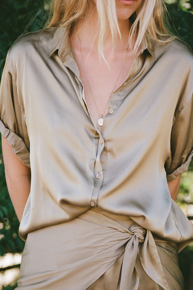 A model wearing a khaki silk mini wrap skirt