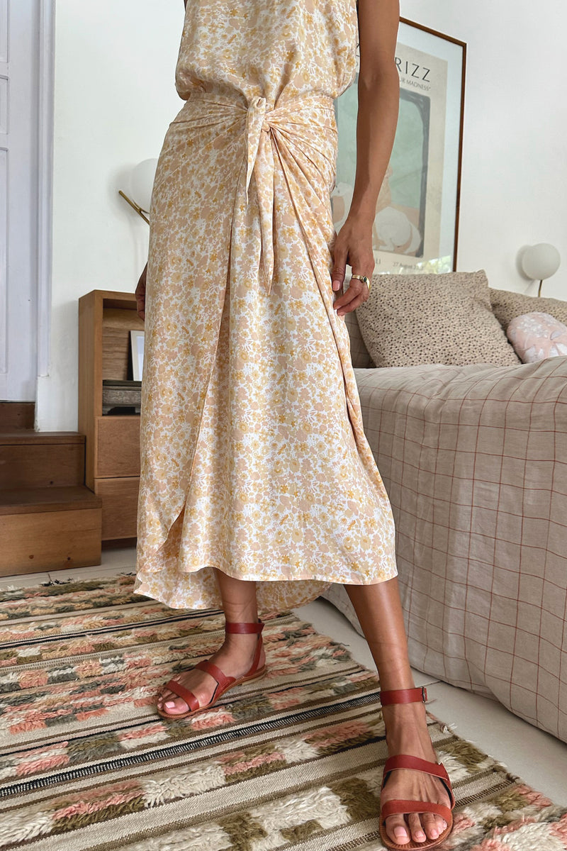 A model wearing a yellow floral midi dress
