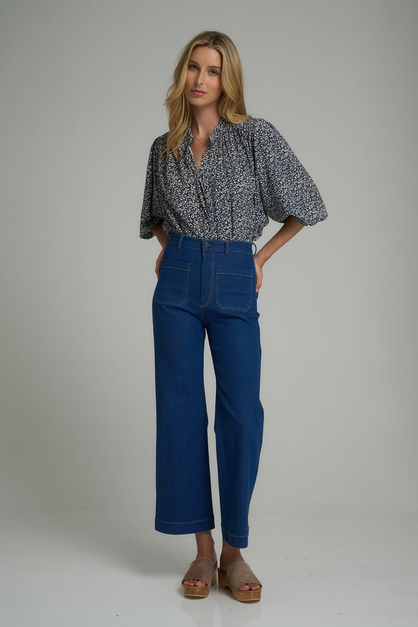 A woman wearing 70's style dark blue denim jeans