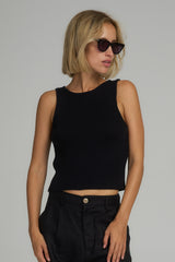 A model wearing a cropped knit black top