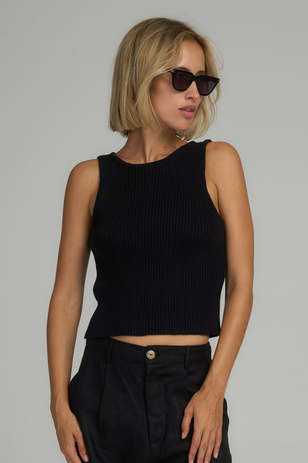 A model wearing a cropped knit black top