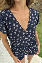 Detail photo of button front of short sleeve top with yarrow flower print.