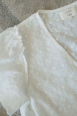Detail photo of the neck label for the LILYA X JKB collection and the sleeve frill detail.