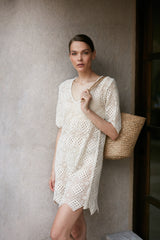 A woman wearing a feminine cream cotton lace dress for Summer