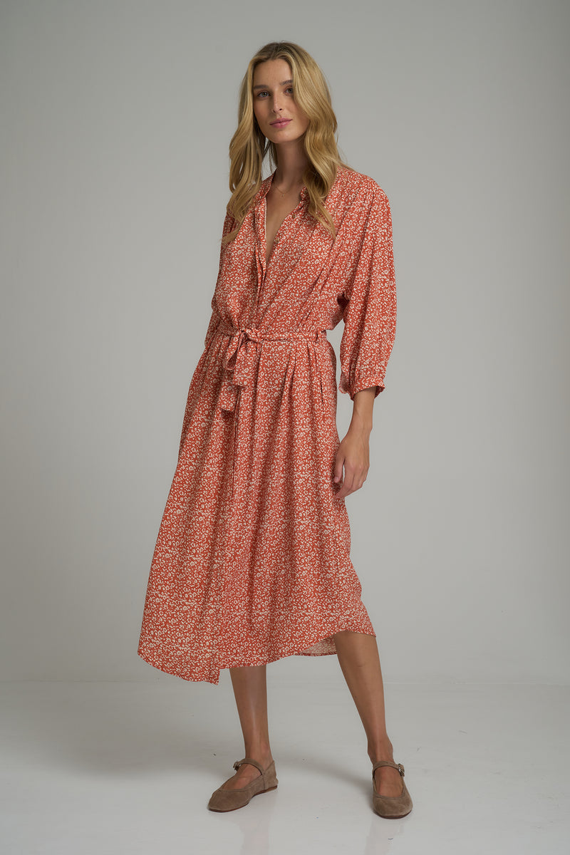 A model wearing a orange floral midi dress