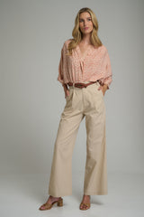 A model wearing a orange and ivory floral blouse