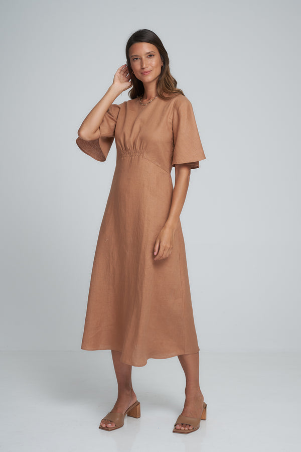 A model wearing a rust coloured linen midi dress